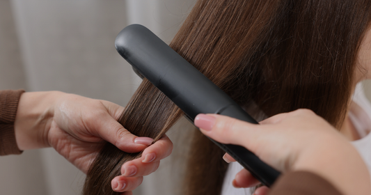 A woman using a straightener or blow-dryer. More lifestyle-focused and relatable, but less specific to Kérastase.