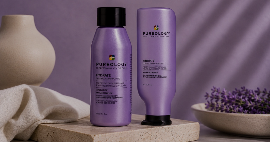 Pureology Hydrate Shampoo and Hydrate Sheer Conditioner displayed on a natural stone plinth in a modern studio setting with soft lavender tones, gentle lighting, and minimalist spa-inspired styling. Designed for dry, colour-treated hair.